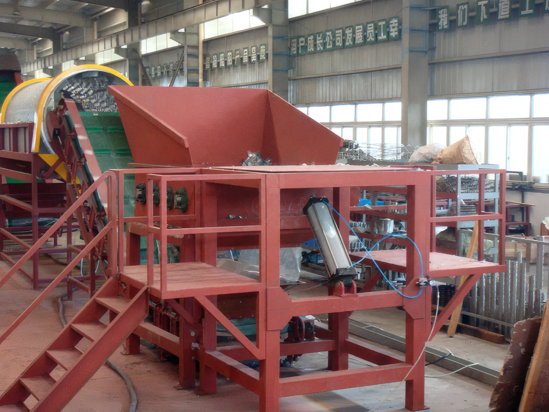 Debaler with red hopper, pneumatic cylinder and access stairs