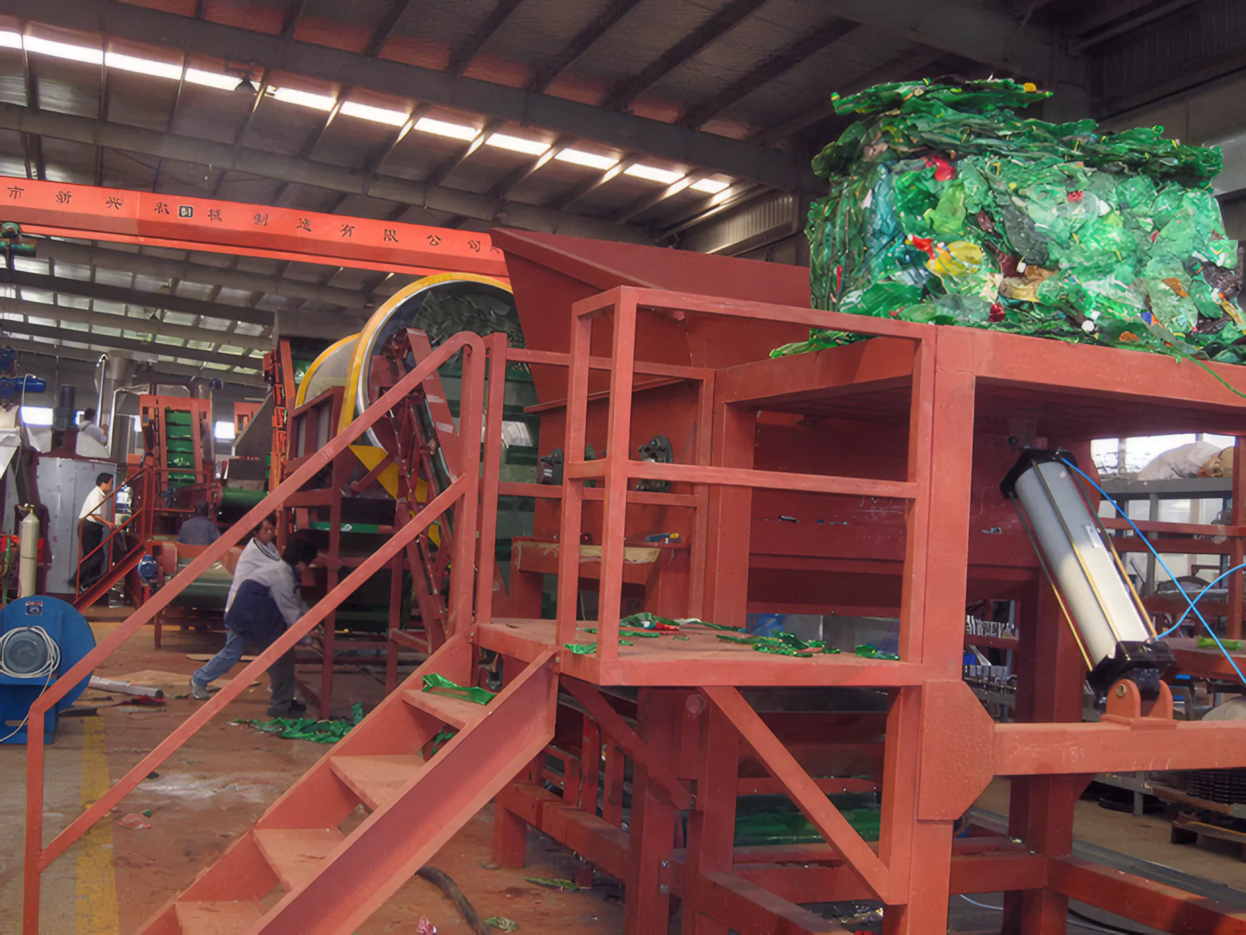 PET bottle bale on the debaler feed table beside the trommel
