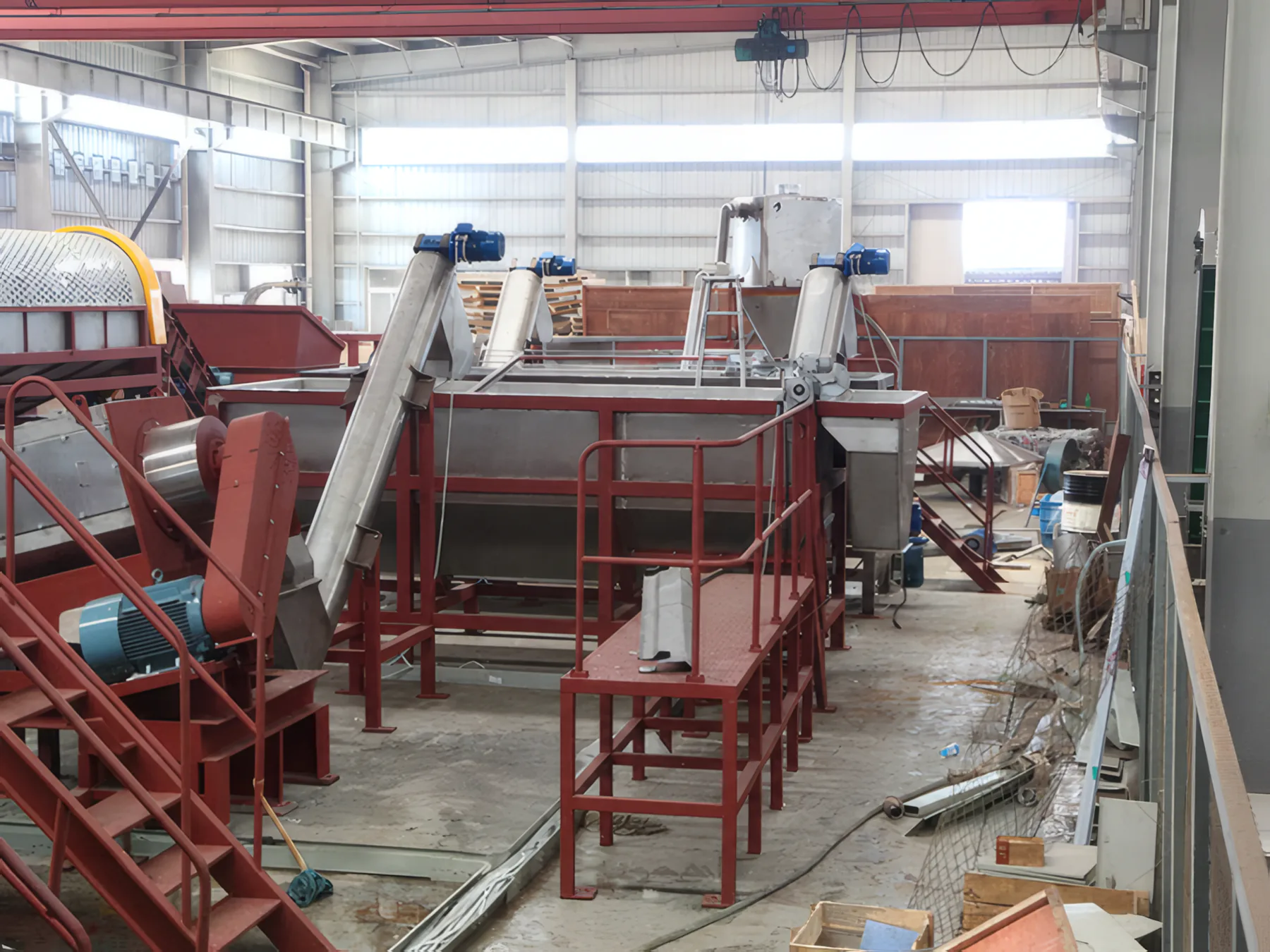 Sink-float tank with screw loaders and red access stairs