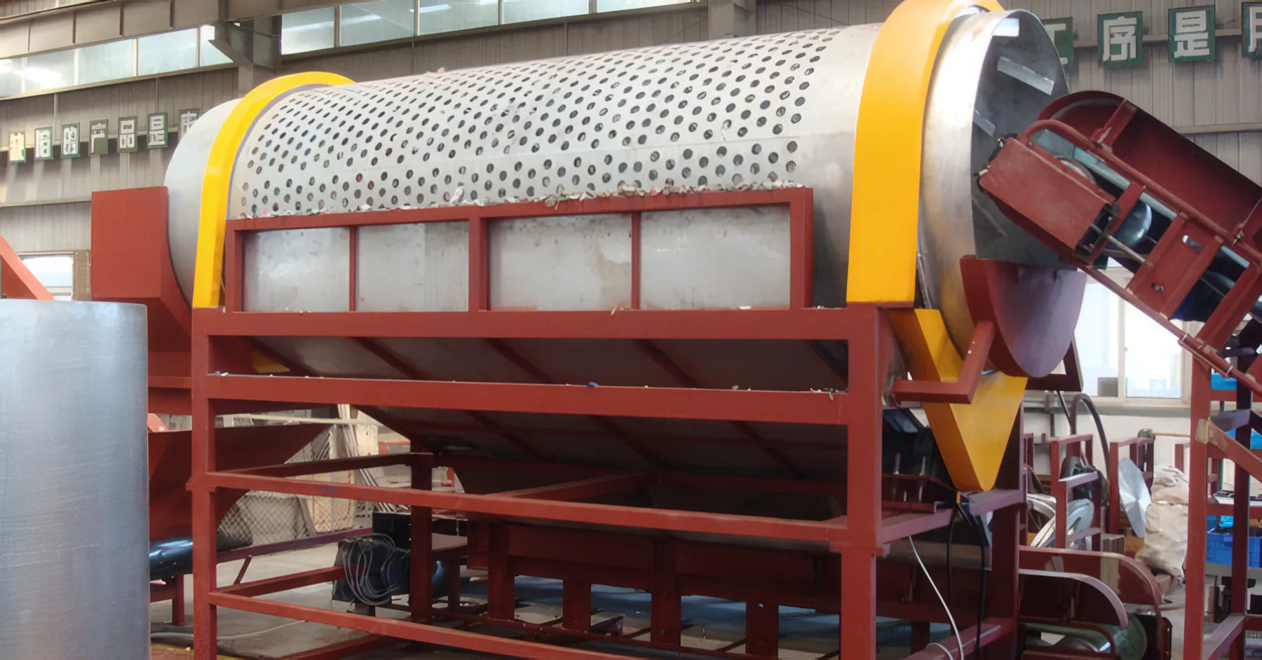 Trommel for PET bottles – perforated drum with yellow ring on a red frame