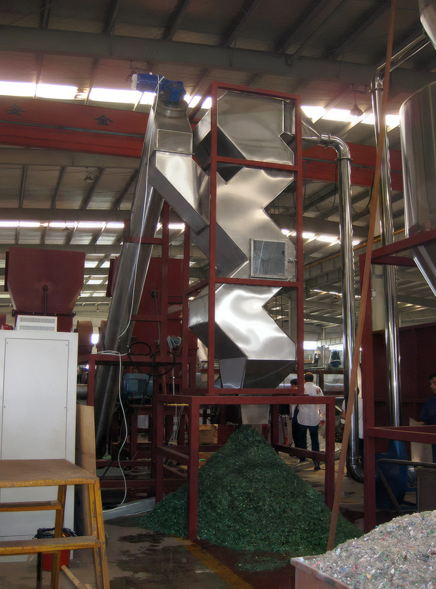 Zig-zag label separator tower above a pile of green PET flakes