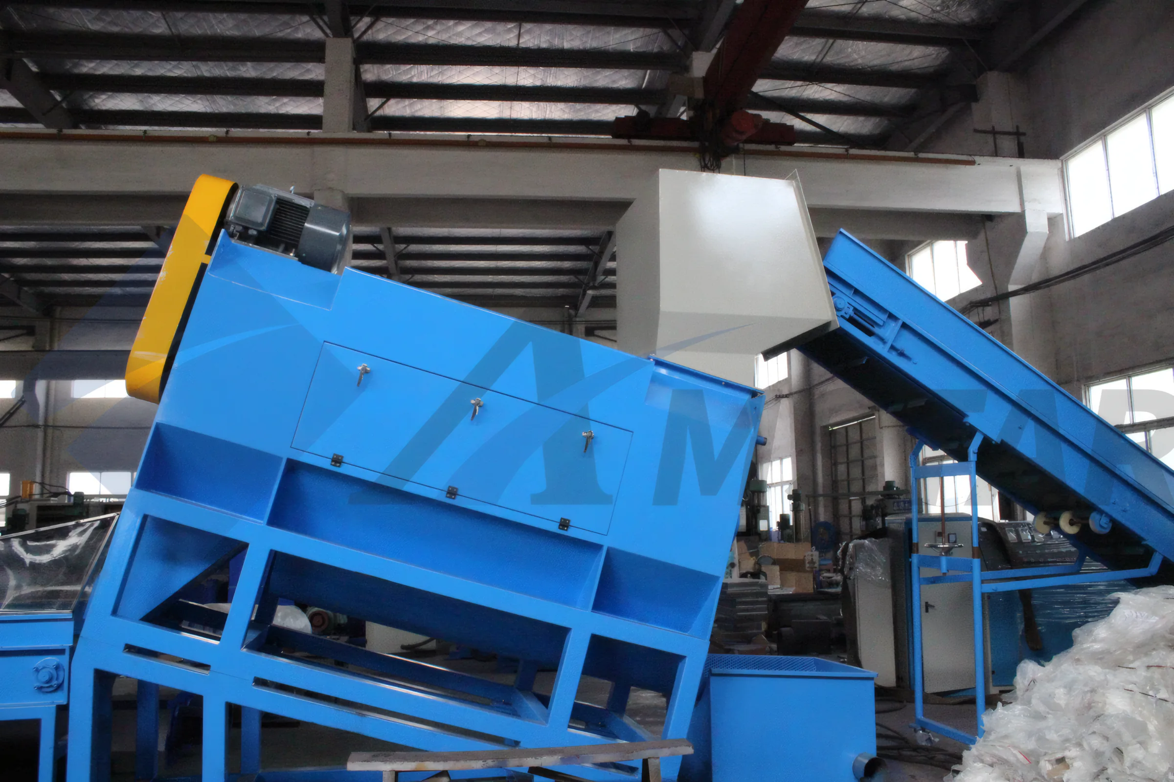 Wet Label Remover – inclined blue housing beside the bottle feed conveyor